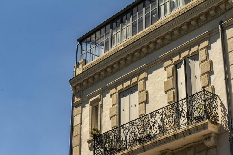 Façade enduite beige sous ciel bleu, illustration d’ambiance pour les travaux d’enduit et ravalement